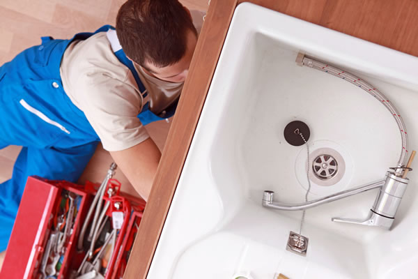 Licensed plumber repairing a sink